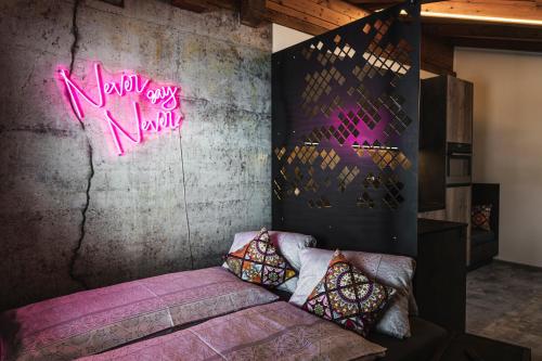 a bedroom with a bed with a neon sign on the wall at PHILSON Apartments in Saalbach Hinterglemm