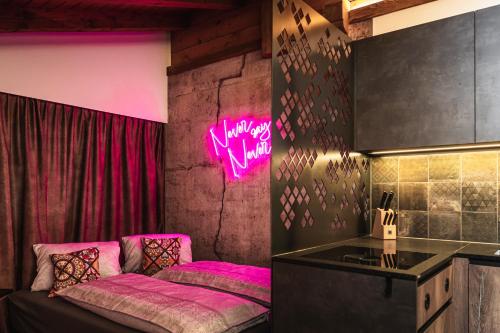 a room with a bed with pink lights on the wall at PHILSON Apartments in Saalbach Hinterglemm