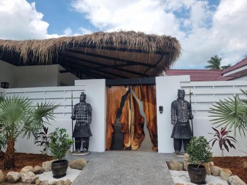 a house with two statues in front of a door at La Belle Vie - Boutique Hotel Adults Only in Baan Tai