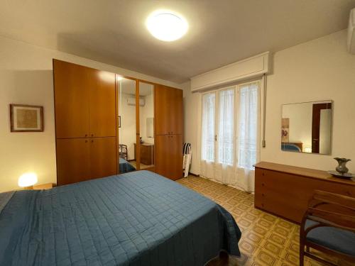 a bedroom with a bed and a dresser and a window at Matchpoint Apartment in Sanremo