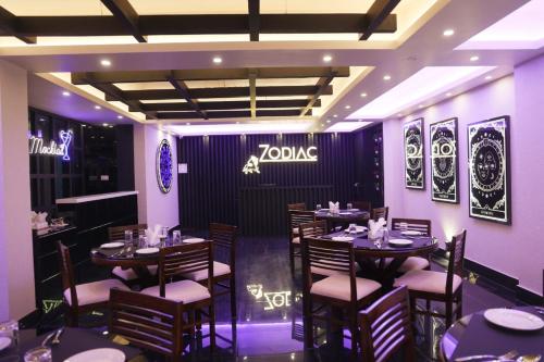 a restaurant with tables and chairs and a sign on the wall at XCELSIOR HOTEL & SPA in Shillong
