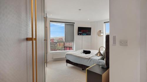 a bedroom with a bed and a window at Modern and Spacious Penthouse Apartment in Putney with Free Parking in London