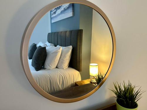 a mirror hanging on a wall with a bed at Hyde Brewery House - 2 bedroom house with parking in Winchester