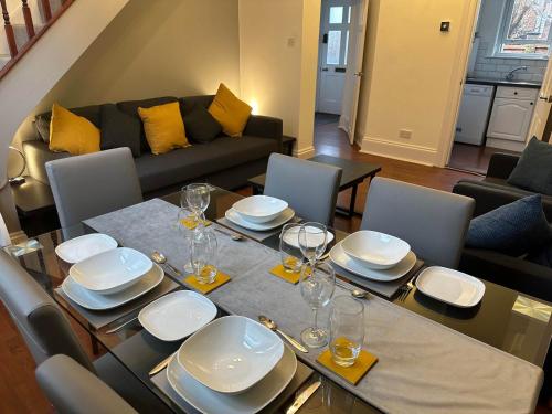 a dining room with a table with plates and wine glasses at Hyde Brewery House - 2 bedroom house with parking in Winchester