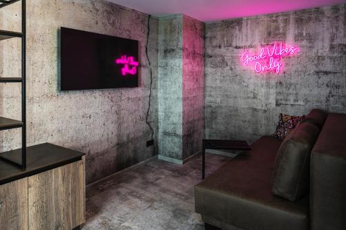 a living room with a couch and a neon sign at PHILSON Apartments in Saalbach Hinterglemm