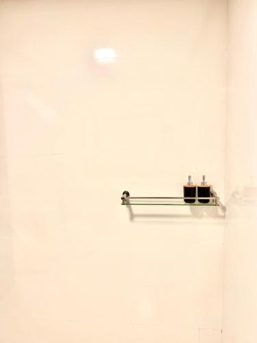 a shelf on a white wall with two bottles on it at Vilu Residence in Maamigili