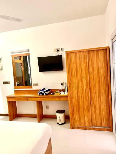 a room with a wooden desk and a mirror at Vilu Residence in Maamigili
