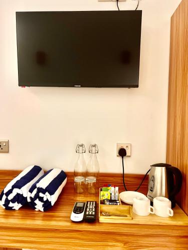 a tv on top of a wooden table with remote controls at Vilu Residence in Maamigili