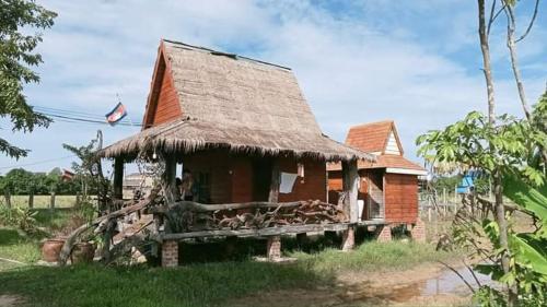 una pequeña casa con techo de paja en Meta Homestay en Puok