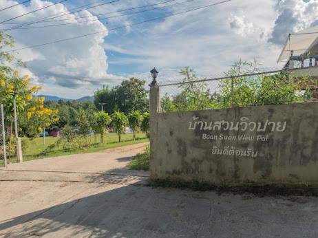 a wall with a sign on it next to a street at Bansuan viewpai in Pai