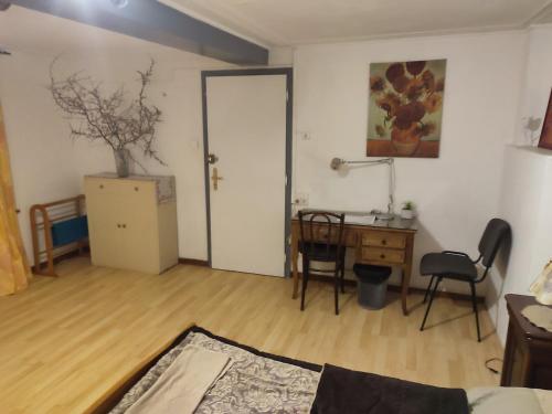 Zimmer mit einem Schreibtisch, einem Tisch und einer Tür in der Unterkunft chambre 21m2 in Zilling
