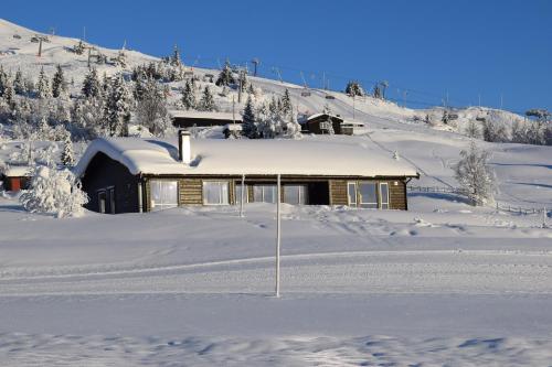 a building covered in snow in front of a mountain at Skeikampen Booking in Svingvoll