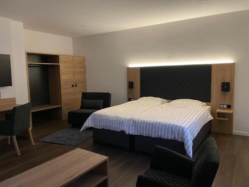 a bedroom with a bed and a desk and chairs at Ferienwohnung Zossen Gästehaus in Zossen