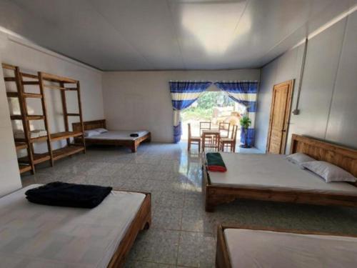 a bedroom with two beds and a table and chairs at Đắk G'lung Bungalow in Bu Yal (1)