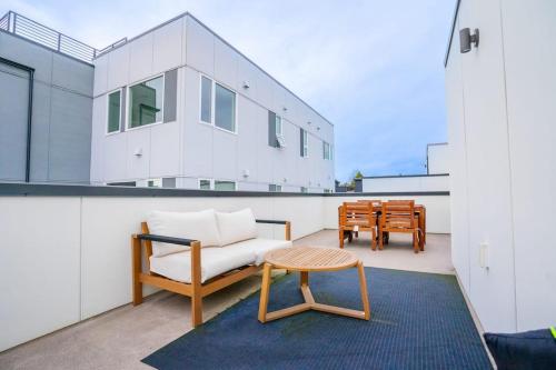 a living room with a couch and a table on a balcony at Ballard's Pet-Friendly Mid Century Home + Rooftop Deck in Seattle