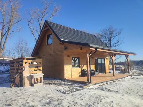 a large wooden cabin in the snow with snow at Dzika Polana in Duszniki Zdrój