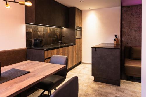 a kitchen with a wooden table and chairs in a room at PHILSON Apartments in Saalbach Hinterglemm