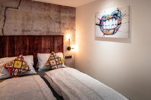 a bedroom with two beds and a painting on the wall at PHILSON Apartments in Saalbach Hinterglemm