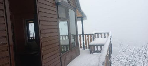 a balcony of a cabin with snow on the windows at chemi kera Chalet in Makho