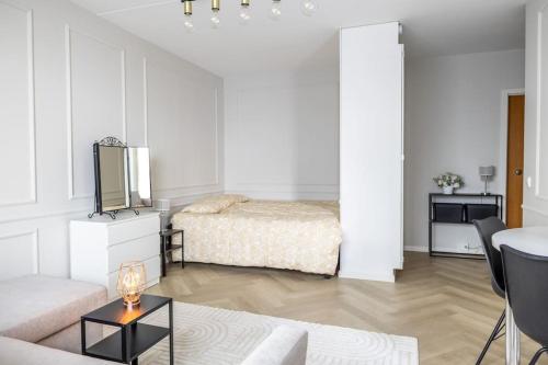 a white living room with a bed and a table at 30m2 studio - 500m from train station to Airport and Helsinki city centre in Vantaa