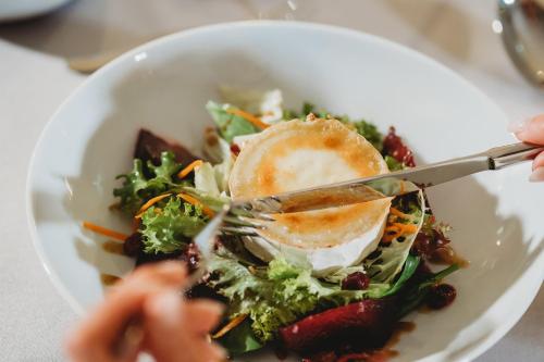 a bowl of food with a fork and knife at Spa & Wellness Hotel Fitak**** in Liptovský Ján