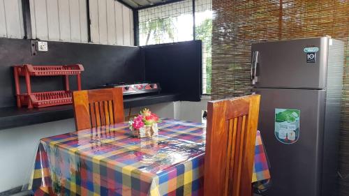 a kitchen with a table and a refrigerator at Blue sky villa in Mirissa