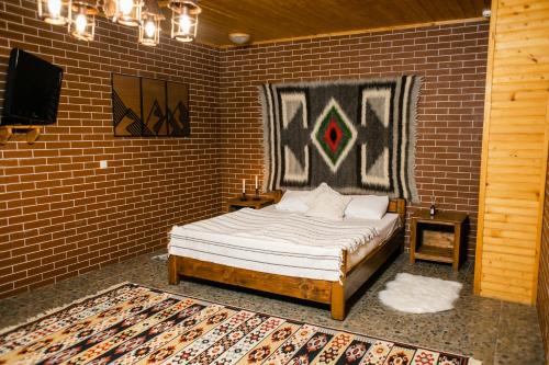 ミホヴォにあるKarpaty Migovoのレンガの壁にベッド1台が備わるベッドルーム1室