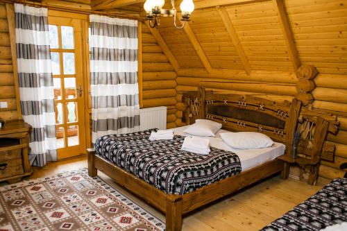 a bedroom with a bed in a log cabin at Karpaty Migovo in Migovo