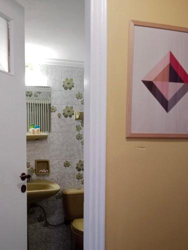 een badkamer met een wastafel en een schilderij aan de muur bij George Traditional House in Pylos