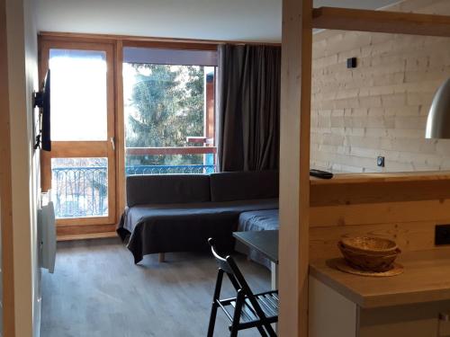 a living room with a couch and a window at Appartement rénové 2 pièces cabine avec balcon - 6 personnes - Wifi inclus - FR-1-346-558 in Arc 1800