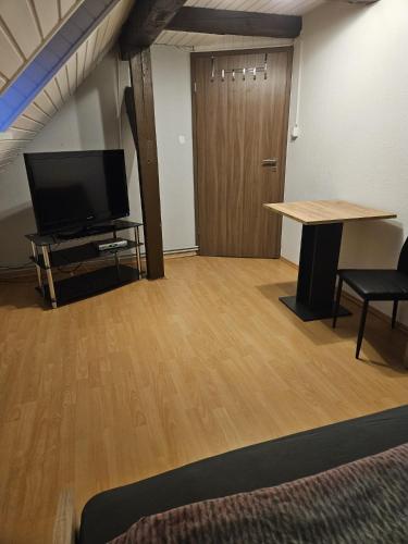um quarto com uma mesa, uma televisão e uma secretária em Monteurzimmer und Pension - Ampfurth em Oschersleben