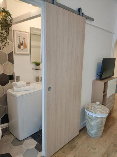 a bathroom with a toilet and a television at Appartement tout équipé au cœur de Fontainebleau in Fontainebleau