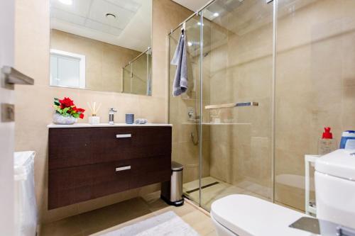 a bathroom with a shower and a sink and a toilet at VayK - Modern 2BD in the Marina near Beach in Dubai