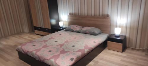 ein Schlafzimmer mit einem Bett und zwei Nachttischen in der Unterkunft Apartament Kostov Sliven in Sliven