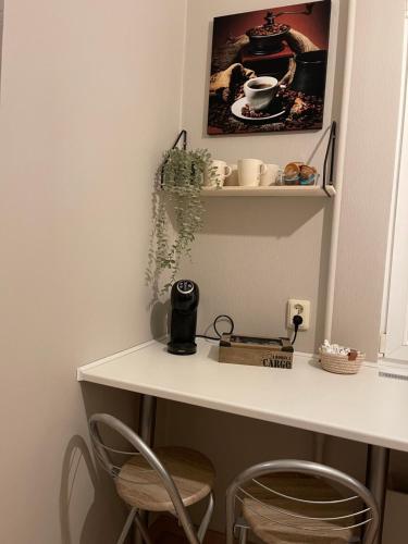 a white table with two chairs and a shelf at Cozy apartment close to Riga Airport in Rīga