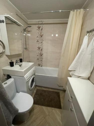 a bathroom with a toilet and a sink and a tub at Cozy apartment close to Riga Airport in Rīga