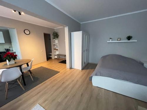 Cozy apartment close to Riga Airport في ريغا: غرفة نوم بسرير وطاولة طعام