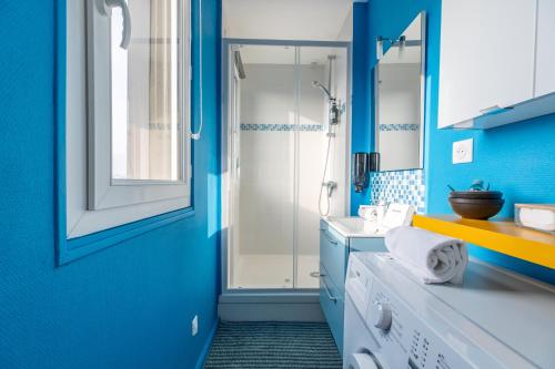une salle de bain bleue avec une douche et un lavabo dans l'établissement Le COCON de Jaude F2 HyperCentre avec ascenseur 52Bonnabaud, à Clermont-Ferrand