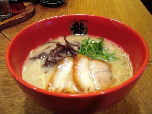 a red bowl of soup with meat and noodles at Kumamoto Washington Hotel Plaza in Kumamoto