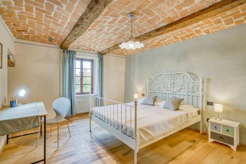 una camera con letto bianco e soffitto in mattoni di Casa Nicola a Belveglio
