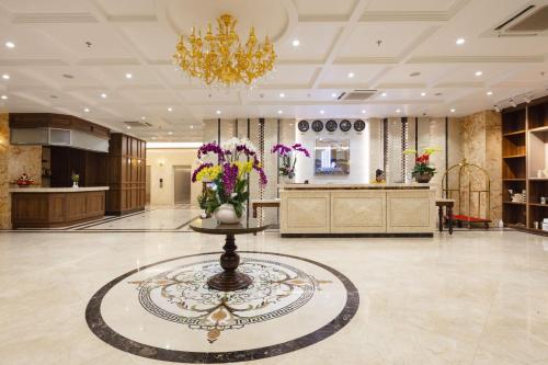 um lobby com uma mesa com flores em Daphovina Hotel em Nha Trang