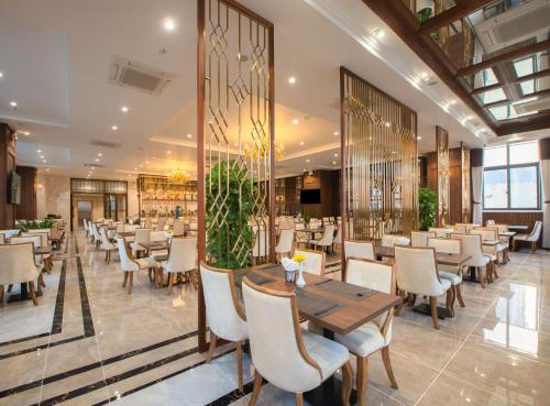 a restaurant with a wooden table and chairs at Daphovina Hotel in Nha Trang