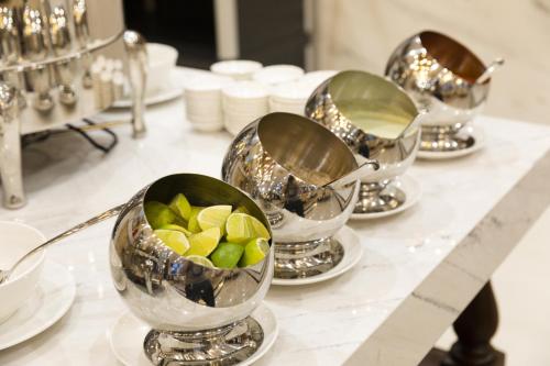a group of silver bowls of fruit on a table at Daphovina Hotel in Nha Trang