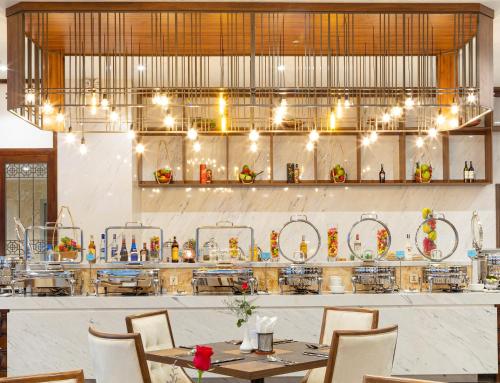 a restaurant with tables and chairs and a chandelier at Daphovina Hotel in Nha Trang