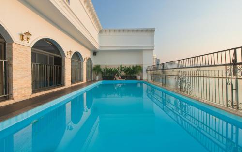 an indoor swimming pool with blue water in a building at Daphovina Hotel in Nha Trang