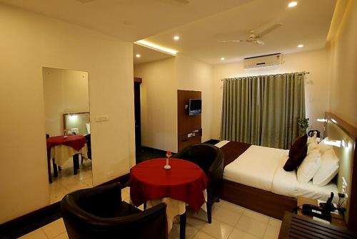 une chambre d'hôtel avec un lit et une table rouge dans l'établissement HOTEL CALICUT GATE, à Ferokh