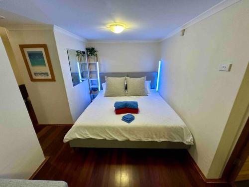 a bedroom with a bed with two towels on it at NY Special Granny Flat in Mosman in Sydney