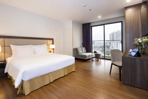 a hotel room with a large bed and a window at Daphovina Hotel in Nha Trang