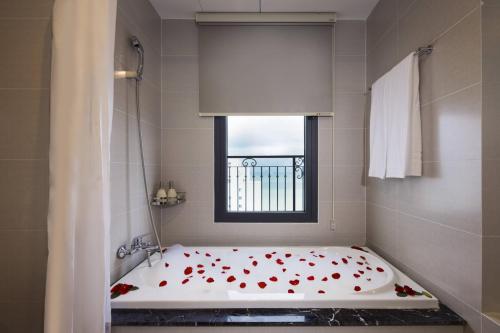 a bathroom with a bath tub with red roses on it at Daphovina Hotel in Nha Trang