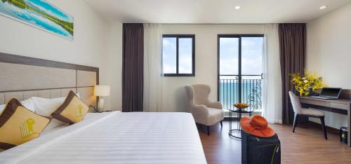 a hotel room with a bed with a desk and a laptop at Daphovina Hotel in Nha Trang
